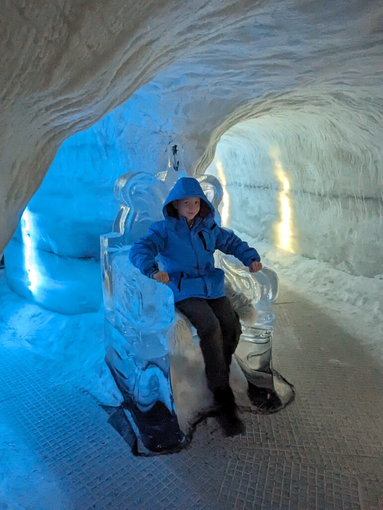 Boy sat on a chair made of ice in Perlan Iceland