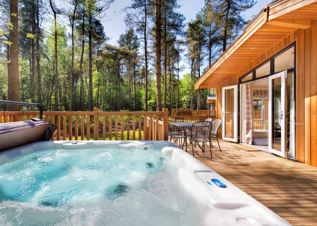 A lodge in a forest with an outdoor hot tub Darwin Forest