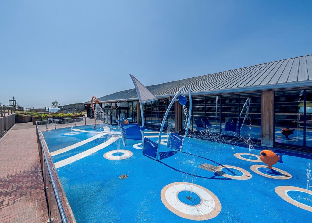 Outdoor splash area with a building behind at Ladram Bay