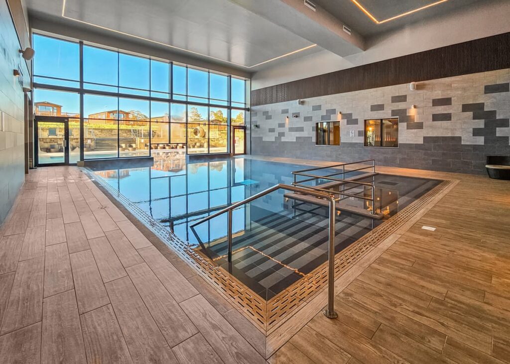 Indoor heated swimming pool with modern design and large glass windows in a top UK holiday park.