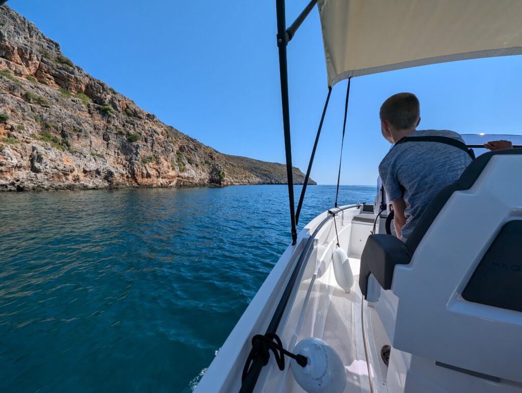 child driving a speed boat in Crete