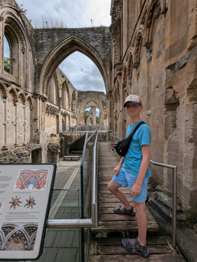 Glastonbury Abbey child stood posing in the ruined chapel